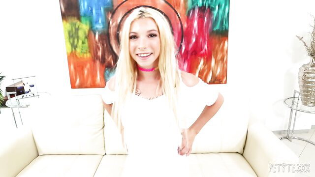 Blonde Kenzie Reeves smiles in white off-shoulder top and pink choker