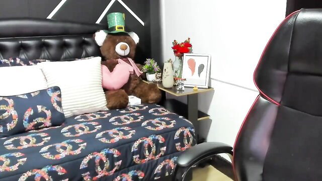 Lauramartinez21 posing with teddy bear on a bed