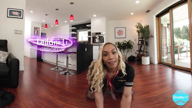 Blonde trans Latoni Li kneels smiling in sporty top on Grooby Girls