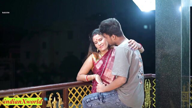 Indian wife in red saree embraces man in hot balcony embrace