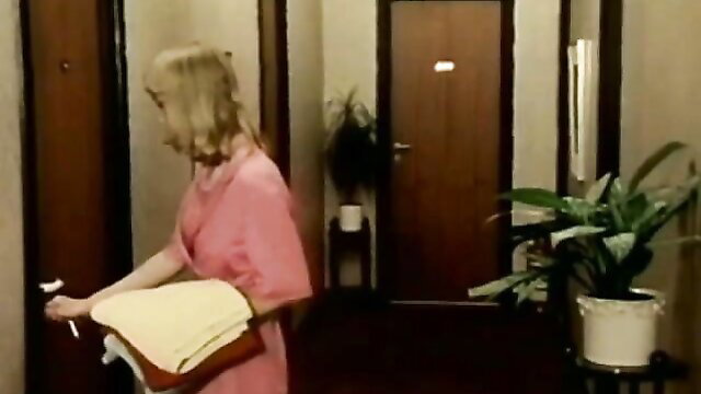 Blonde in pink dress with towels in hotel hallway, vintage XXX