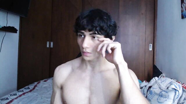 Young Latin twink Aresholland shirtless in bedroom, curly hair pose