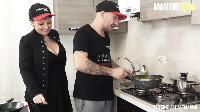Redhead granny Barbara Gandalf in black dress with chef hat cooking