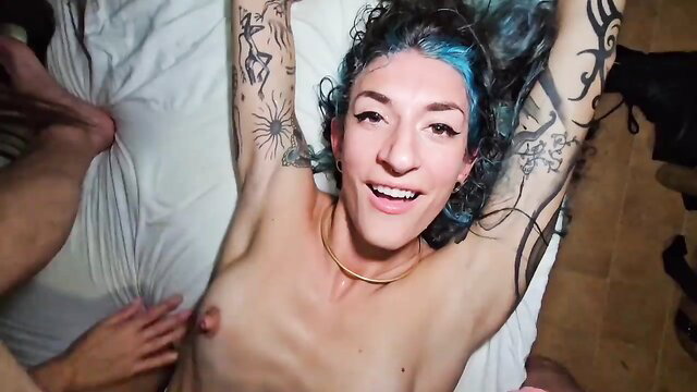 Tattooed blue-haired alt girl nude smiling in rough threesome fuckfest