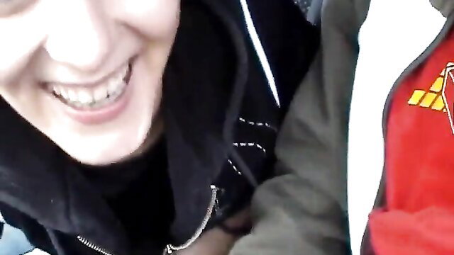 Smiling Asian girl in hoodie flashes braces in car POV thumbnail