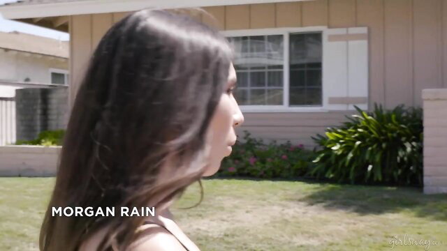 Morgan Rain outside stucco house in sundress, sultry profile view