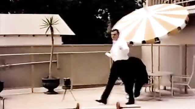 Man in suit holding giant umbrella on balcony in vintage erotic scene