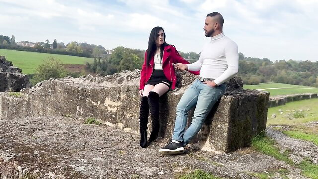 Marina from Biarritz in sexy red blazer, mini skirt & thigh-high boots with man on ruins