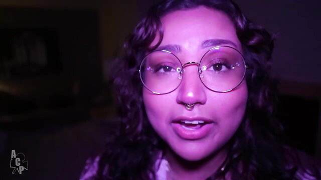 Lonely Asian wife in glasses smiles seductively in purple light HD porn
