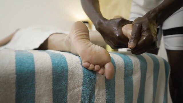 Julia North's soles massaged by ebony masseur in erotic treatment