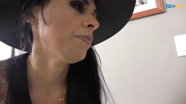 Tattooed Latina in black hat smirks in Candy Farts adult video thumbnail