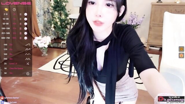 Chinese camgirl in black bowtie top and skirt poses seductively