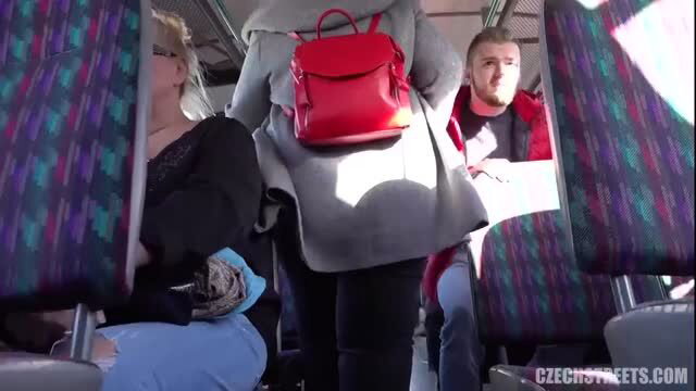 Luxurious mommy in gray coat with red backpack on public bus