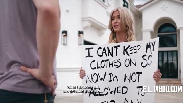 Blonde teen Emma Rosie holding sign punishment sign outdoors