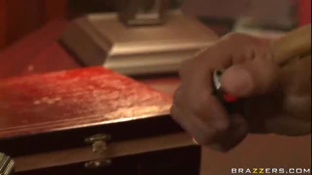 Hand holding lit lighter over red wooden box