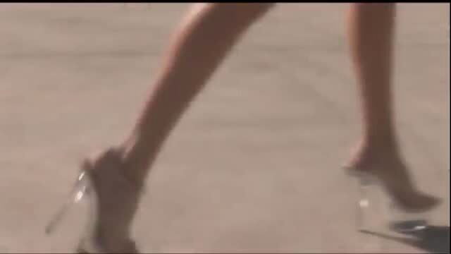 Sindee Jennings in clear high heels, bare legs on concrete