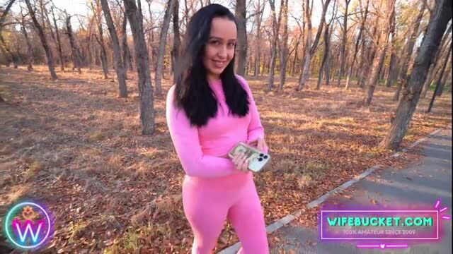 Amateur MILF in pink catsuit holding money outdoors
