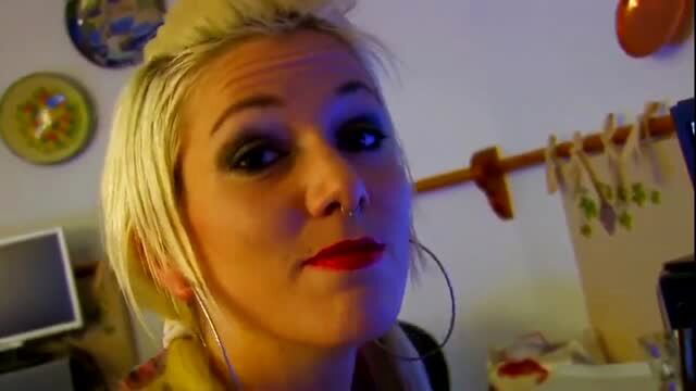 Short-haired blonde with nose ring and hoop earrings in dim lighting