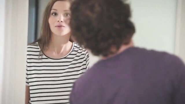 Brunette MILF in striped top faces man from behind in teasing pose