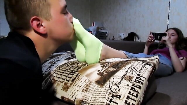 Blonde boy kisses amateur girl's lime green socks and bare feet on couch