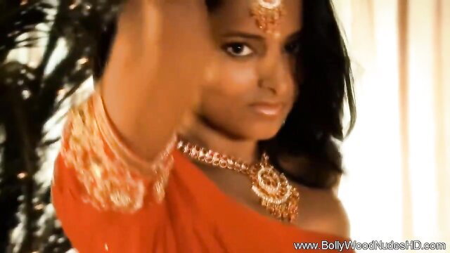 Bollywood Indian beauty in sexy red saree, heavy gold jewelry, seductive pose