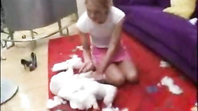 Kylie Richards kneeling in pink skirt playing with white fluffy toy