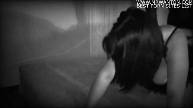 Asian woman in lingerie bent over bed in dark bedroom amateur scene