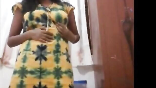 African beauty in tight yellow-green tie-dye dress, teasing pose