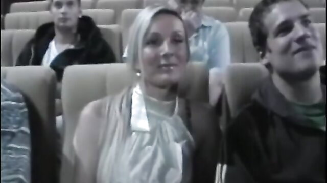 Nikki Silver in silver dress smiling in theater seats