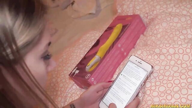 Busty blonde babe unboxing yellow vibrator on bed
