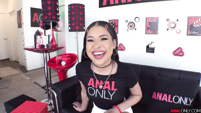 Hot Latina babe with pigtails smiling on ANAL ONLY set, oiled ass tease