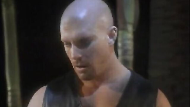 Bald muscular hunk in leather vest from vintage Sin City group sex porno