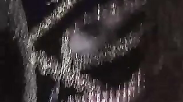 Dark shadowy closeup of woman's intense eyes and face in BDSM tease