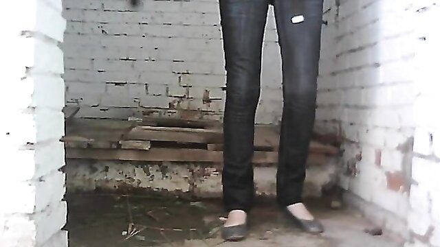 Skinny brunette in tight jeans in gritty Soviet toilet