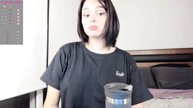 Hot Asian babe in black tee holds tumbler on Chaturbate cam show