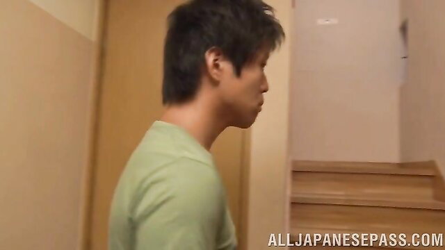 Side profile of handsome Japanese man in green shirt at doorway