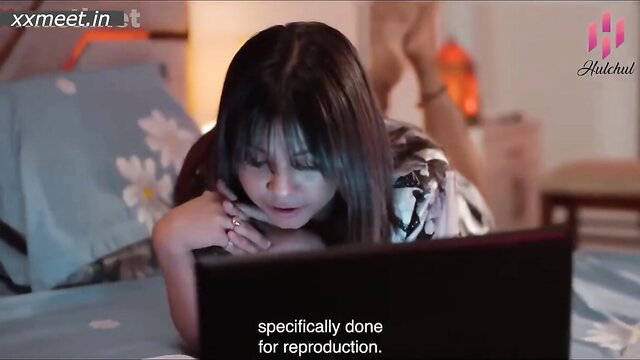 Asian beauty with bangs leans on laptop in bed, POV seduction