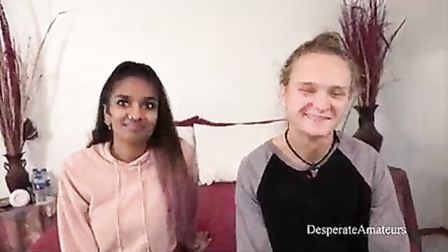 Desperate Amateurs - Smiling black and white girl smiling on couch in pink hoodie