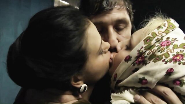 Brunette woman passionately French kisses man holding blonde baby in arms