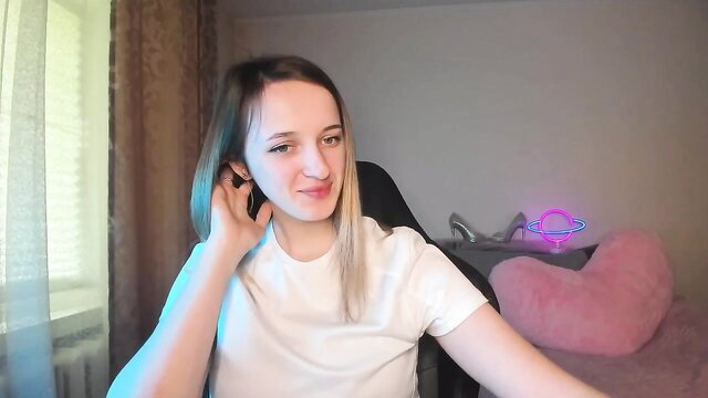 RouseReed on MyFreeCams, cute pale brunette smiling in white tee