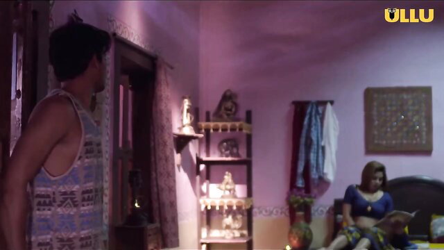 Desi Maami Ki Garmi in blue saree sits sexy on bed, man watches from door
