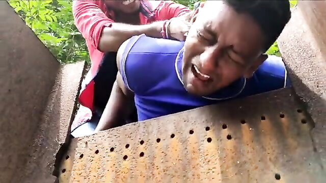 Black man gutpunched hard by another guy, grimacing in pain outdoors