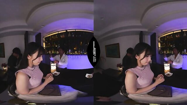 Naughty Asian vixen in pink dress sips drink at dimly lit bar