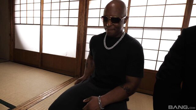 Naomi Togo with two suited black men in Japanese room
