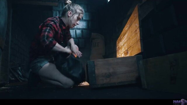 Blonde in plaid shirt and shorts rummages crates in dark Parasited scene