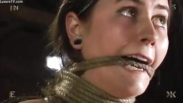 Bound hitchhiker gagged with rope, wide-eyed fear in dim light
