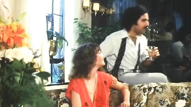 Vintage 80s couple in sexy red dress and suspenders toasting champagne