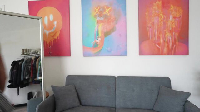 Amateur try-on haul in stylish room with KAWS art, gray couch mirror setup