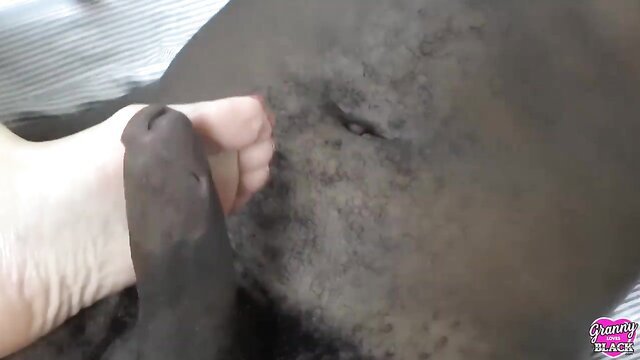 Granny footjob on lubed black cock in GrannyLovesBlack video