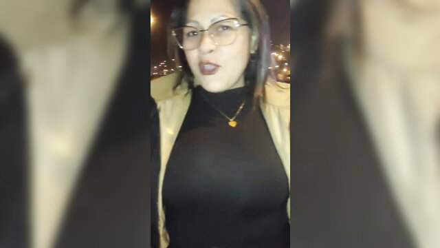 Mature Venezuelan woman in glasses and black top at night party